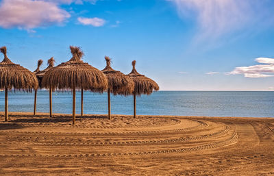 Straw umbrellas on empty seaside beach