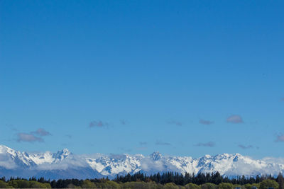 Scenic view of snowcapped mountains against clear blue sky