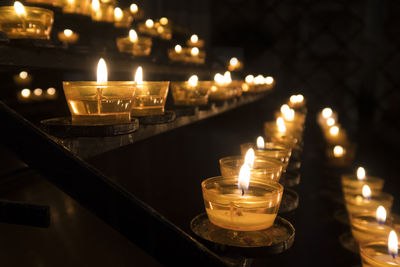 Close-up of illuminated tea light candles in temple