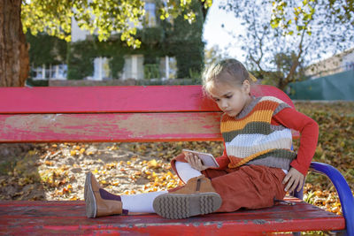 Girl looking away while sitting in park