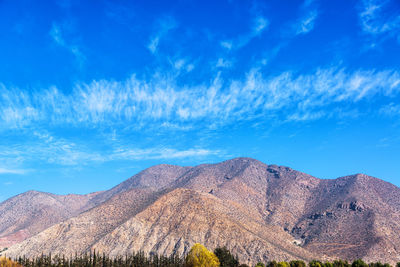 Scenic view of mountains against blue sky