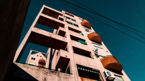 Low angle view of buildings against clear blue sky