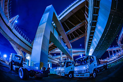 View of bridge in city against blue sky at night