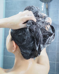 Rear view of woman in bathroom