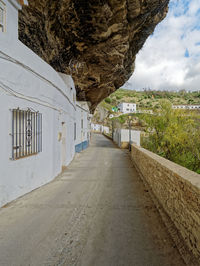 Road amidst buildings against sky