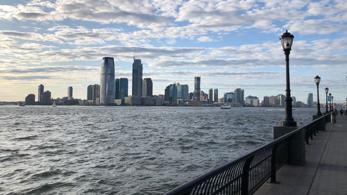 Modern buildings in city against cloudy sky