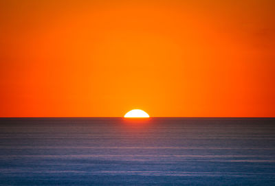 Scenic view of sea against orange sky