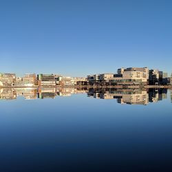 Buildings in city against clear blue sky