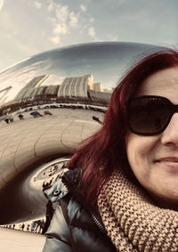 Portrait of beautiful woman wearing sunglasses against sky