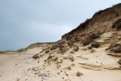 Scenic view of sandy beach against cloudy sky