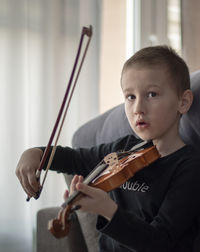 Boy playing violin at home