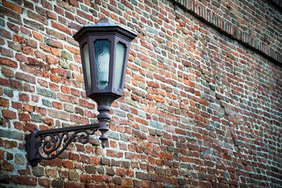 Low angle view of street light on brick wall