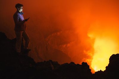 Full length of woman looking at volcanic eruption