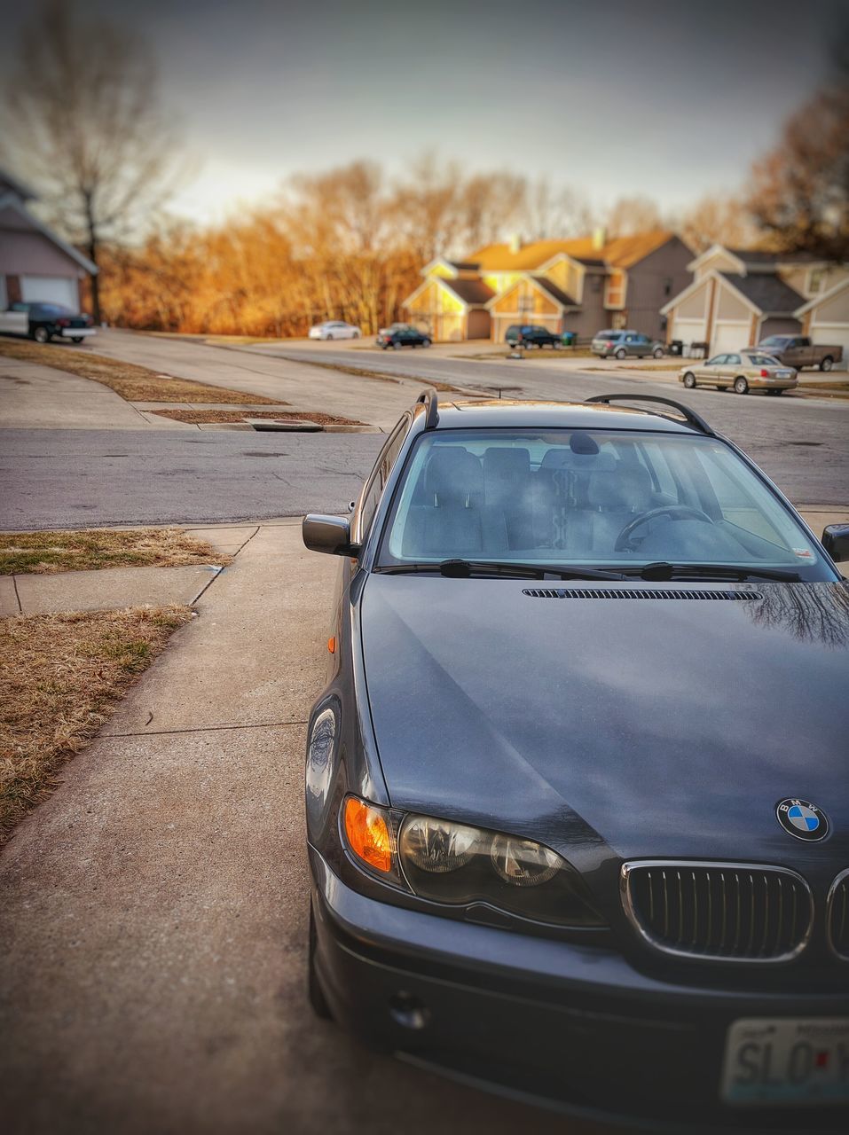 transportation, mode of transport, land vehicle, car, street, road, travel, sky, on the move, stationary, outdoors, traffic, sunset, parking, vehicle, road marking, city, focus on foreground, sunlight, no people