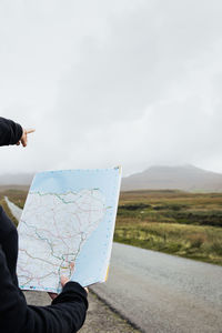 Man taking selfie on road against sky