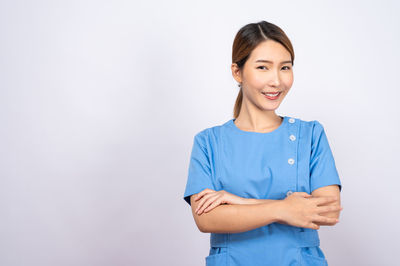 Portrait of a smiling young woman against white background