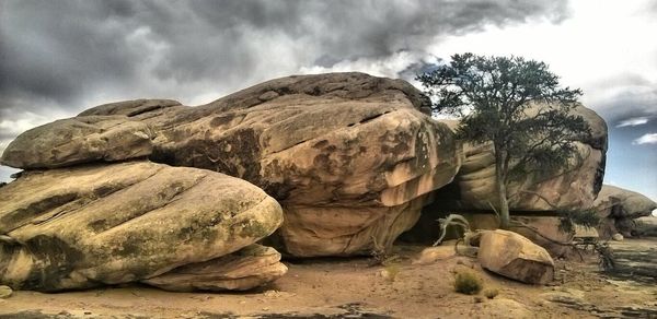 Scenic view of rock formation against cloudy sky