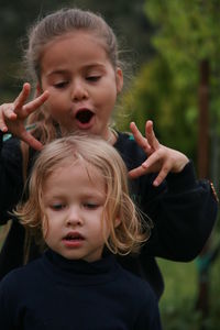 Portrait of cute girl with baby holding hands