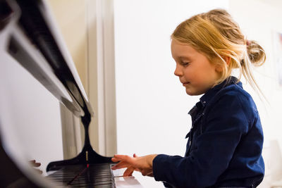 Profile view of girl playing piano