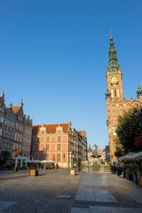 View of buildings in city against blue sky