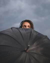 Low angle portrait of woman against sky