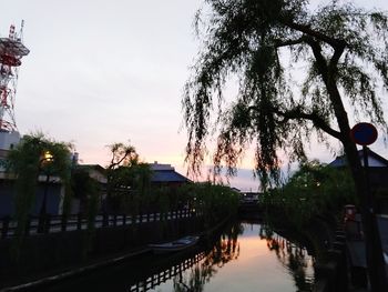 Canal amidst buildings against sky during sunset