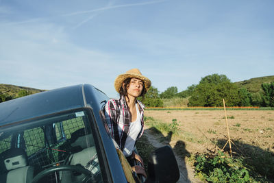 Young woman wearing hat looking away through car