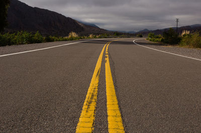 Surface level of empty road against mountain