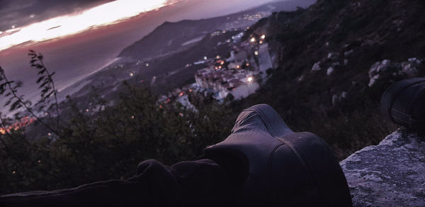 Low section of people on mountain against sky in city