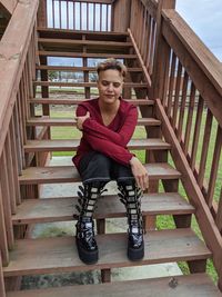 Portrait of young woman sitting on staircase