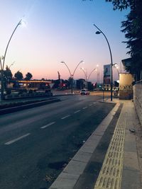 City street against sky at dusk