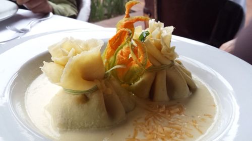 Close-up of hand holding ice cream in plate