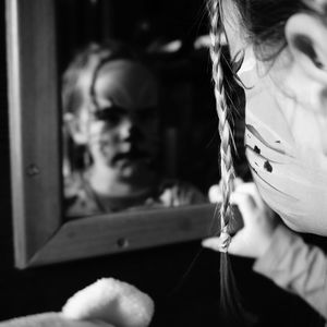 Cropped image of girl looking in mirror