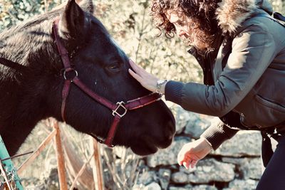 Side view of young woman with horse 