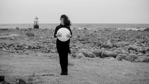 Rear view of woman standing on field against sky