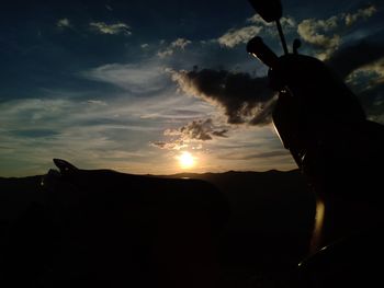 Silhouette person against sky during sunset