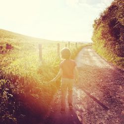 Silhouette of boy standing on path