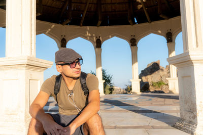 Man wearing sunglasses while siting in gazebo