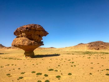 Rock formations in desert against clear blue sky