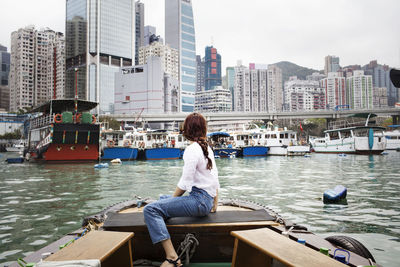 Side view of female tourist looking at buildings by sitting on boat