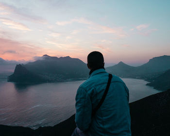 Rear view of man looking at sea against sky