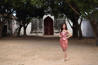 Full length of woman standing against trees