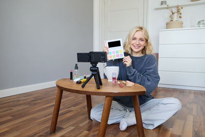 Portrait of young woman sitting on chair at home