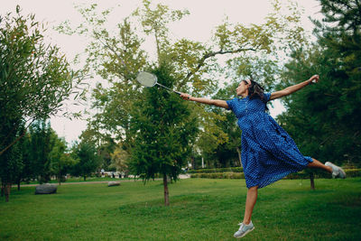 Full length of happy young woman on field