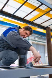 Side view of young man working at construction site