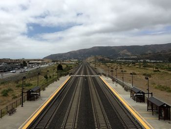 Railroad track against cloudy sky