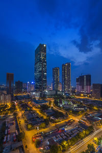 Illuminated buildings in city against sky at night