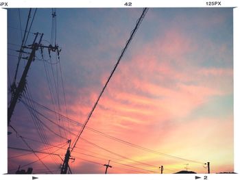 Low angle view of electricity pylon against cloudy sky