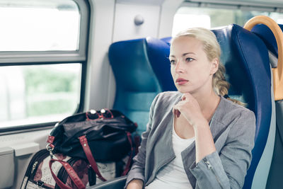Portrait of young woman sitting in car