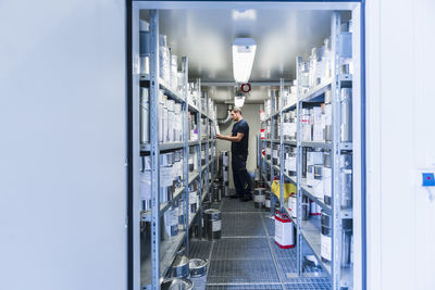 Man in storage room with paint bucket